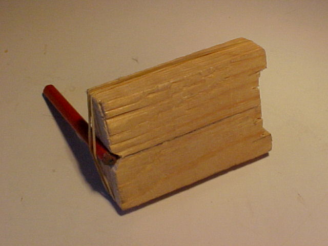 Wooden block, pencil and rubber bands